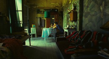 Movie still from “Happy Together” (1997), directed by Kar-Wai Wong – A person sitting at a table in a room; Wide shot, High angle