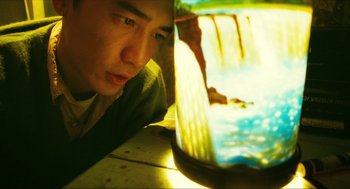 Movie still from “Happy Together” (1997), directed by Kar-Wai Wong – A man looking at the camera while laying down; Medium shot, High angle