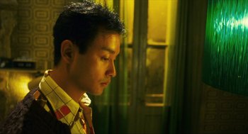 Movie still from “Happy Together” (1997), directed by Kar-Wai Wong – A young man is standing in front of a window; Close Up shot, High angle
