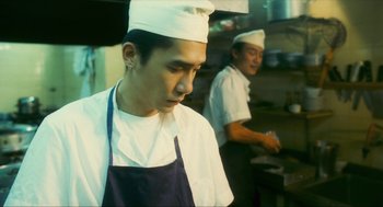 Movie still from “Happy Together” (1997), directed by Kar-Wai Wong – A man wearing a chef's hat in a restaurant kitchen; Close Up shot, Low angle