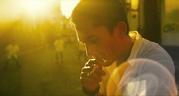 Movie still from “Happy Together” (1997), directed by Kar-Wai Wong – A young man is smoking a cigarette in the sunlight; Close Up shot, Low angle