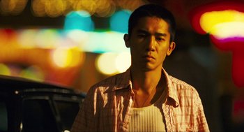Movie still from “Happy Together” (1997), directed by Kar-Wai Wong – A man in a plaid shirt is standing in the street; Close Up shot, Low angle