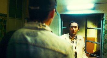 Movie still from “Happy Together” (1997), directed by Kar-Wai Wong – A man looking at himself in the mirror; Medium shot, Over the shoulder angle