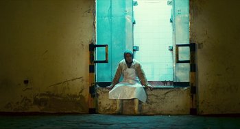 Movie still from “Happy Together” (1997), directed by Kar-Wai Wong – A man sitting on the ground in front of a window; Wide shot, Low angle