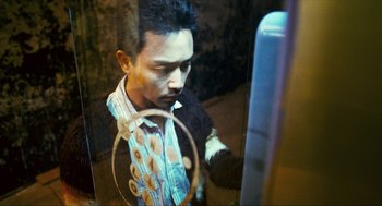Movie still from “Happy Together” (1997), directed by Kar-Wai Wong – A man is looking at the reflection of himself in a mirror; Close Up shot, High angle