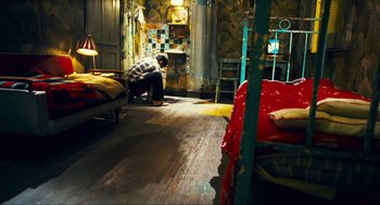 Movie still from “Happy Together” (1997), directed by Kar-Wai Wong – A man kneeling on the ground in a room; Wide shot, High angle
