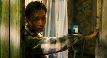 Movie still from “Happy Together” (1997), directed by Kar-Wai Wong – A man in a plaid shirt pointing at the camera; Close Up shot, High angle