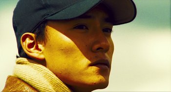 Movie still from “Happy Together” (1997), directed by Kar-Wai Wong – A person wearing a hat; Close Up shot, Low angle