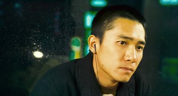 Movie still from “Happy Together” (1997), directed by Kar-Wai Wong – A person wearing headphones; Close Up shot, High angle