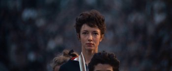 Movie still from “Tokyo Olympiad” (1965), directed by Kon Ichikawa – A person with a medal around their neck; Close Up shot, Low angle