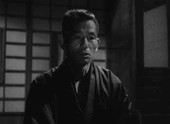A black and white photo of a man wearing a robe
