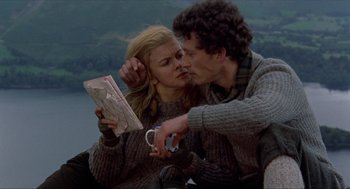 Movie still from “Tommy” (1975), directed by Ken Russell – A man and a woman kissing while looking at a map; Medium shot, High angle