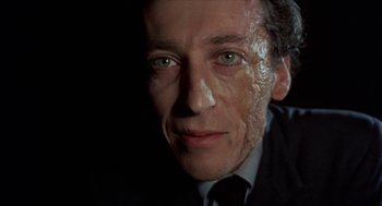 Movie still from “Tommy” (1975), directed by Ken Russell – A person wearing a suit and tie; Close Up shot, Low angle