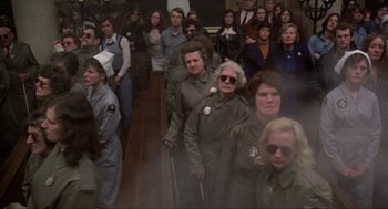 Movie still from “Tommy” (1975), directed by Ken Russell – A group of people standing in front of a wall; Wide shot, High angle