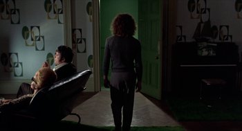 Movie still from “Tommy” (1975), directed by Ken Russell – A woman is walking down the hall way; Wide shot, High angle