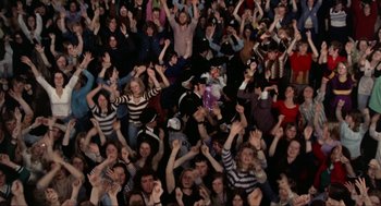 Movie still from “Tommy” (1975), directed by Ken Russell – A large group of people are gathered together; Wide shot, High angle