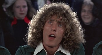 Movie still from “Tommy” (1975), directed by Ken Russell – A person with long curly hair; Close Up shot, Low angle