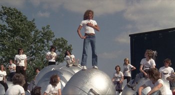 Movie still from “Tommy” (1975), directed by Ken Russell – A man standing on top of a silver ball; Wide shot, Low angle