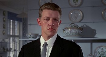 Movie still from “Topaz” (1969), directed by Alfred Hitchcock – A person wearing a suit and tie; Close Up shot, Low angle