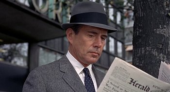 Movie still from “Topaz” (1969), directed by Alfred Hitchcock – A man in a suit and hat reading a newspaper; Close Up shot, Over the shoulder angle