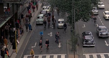 Movie still from “Topaz” (1969), directed by Alfred Hitchcock – A group of bicyclists riding down the street; Extreme Wide shot, High angle