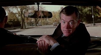 Movie still from “Topaz” (1969), directed by Alfred Hitchcock – A man sitting in the driver's seat of a car; Close Up shot, Over the shoulder angle
