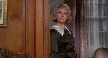 Movie still from “Topaz” (1969), directed by Alfred Hitchcock – A woman with blonde hair wearing a black dress; Close Up shot, Over the shoulder angle