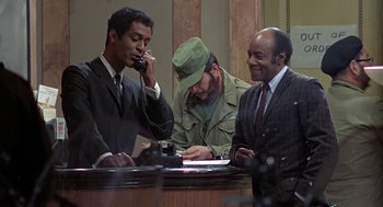 Movie still from “Topaz” (1969), directed by Alfred Hitchcock – A group of men sitting around a table; Medium shot, Over the shoulder angle