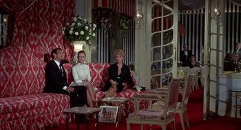 Movie still from “Topaz” (1969), directed by Alfred Hitchcock – A group of people sitting on a couch in a living room; Wide shot, High angle