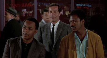 Movie still from “Topaz” (1969), directed by Alfred Hitchcock – A man standing next to two other men in a room; Medium shot, Low angle