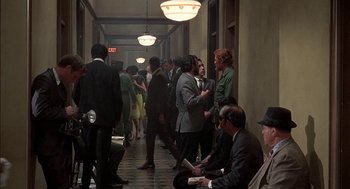 Movie still from “Topaz” (1969), directed by Alfred Hitchcock – A group of people standing in a hallway next to each other; Wide shot, High angle