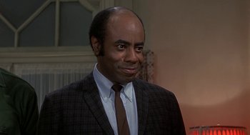 Movie still from “Topaz” (1969), directed by Alfred Hitchcock – A man wearing a suit and tie in front of a window; Close Up shot, Over the shoulder angle