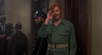 Movie still from “Topaz” (1969), directed by Alfred Hitchcock – A man with a red beard and a police uniform; Medium shot, Over the shoulder angle