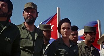 Movie still from “Topaz” (1969), directed by Alfred Hitchcock – A group of men and women standing next to each other in front of a flag; Medium shot, Low angle