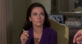Movie still from “Topaz” (1969), directed by Alfred Hitchcock – A beautiful woman holding a pen in her hand; Close Up shot, Over the shoulder angle
