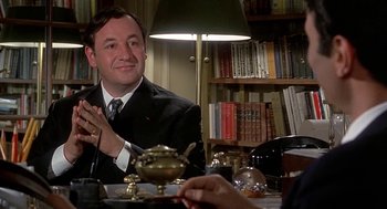 Movie still from “Topaz” (1969), directed by Alfred Hitchcock – A man sitting at a table in front of a lamp; Close Up shot, Over the shoulder angle
