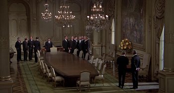 Movie still from “Topaz” (1969), directed by Alfred Hitchcock – A group of men standing around a large wooden table; Extreme Wide shot, High angle