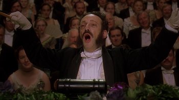 Movie still from “Topsy-Turvy” (1999), directed by Mike Leigh – A man with a beard is singing in front of an audience; Close Up shot, Low angle