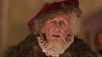 Movie still from “Topsy-Turvy” (1999), directed by Mike Leigh – An old man dressed as a pirate with a red hat and beard; Close Up shot, Low angle