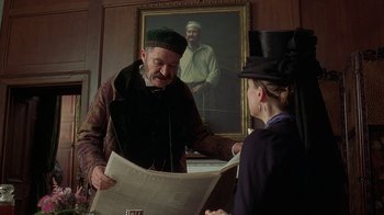 Movie still from “Topsy-Turvy” (1999), directed by Mike Leigh – An old man and a young woman are reading a newspaper; Medium shot, Over the shoulder angle