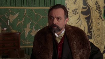 Movie still from “Topsy-Turvy” (1999), directed by Mike Leigh – A man with a beard wearing a fur coat; Close Up shot, Low angle