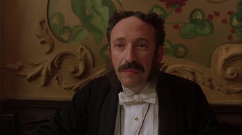 Movie still from “Topsy-Turvy” (1999), directed by Mike Leigh – A person wearing a suit and bow tie; Close Up shot, Low angle