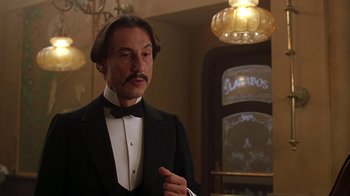 Movie still from “Topsy-Turvy” (1999), directed by Mike Leigh – A man in a suit and bow - tie in front of a mirror; Close Up shot, Low angle