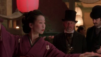 Movie still from “Topsy-Turvy” (1999), directed by Mike Leigh – A woman in a purple dress and a man in a top hat; Medium shot, Low angle