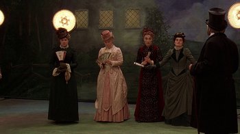 Movie still from “Topsy-Turvy” (1999), directed by Mike Leigh – A group of women dressed in victorian clothing; Wide shot, Low angle