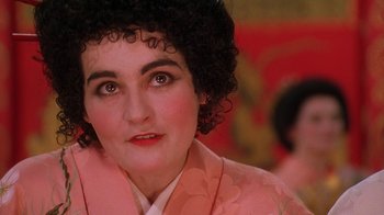 Movie still from “Topsy-Turvy” (1999), directed by Mike Leigh – A person wearing a pink jacket; Close Up shot, Over the shoulder angle