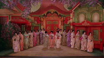 Movie still from “Topsy-Turvy” (1999), directed by Mike Leigh – A group of people dressed in traditional japanese clothing; Extreme Wide shot, High angle