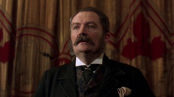 Movie still from “Topsy-Turvy” (1999), directed by Mike Leigh – A person wearing a suit and tie; Close Up shot, Low angle