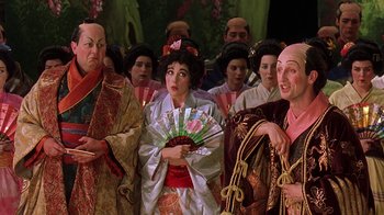 Movie still from “Topsy-Turvy” (1999), directed by Mike Leigh – A group of people dressed in oriental clothing; Medium shot, High angle
