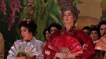 Movie still from “Topsy-Turvy” (1999), directed by Mike Leigh – A group of women dressed up as geishas holding fans; Close Up shot, Low angle